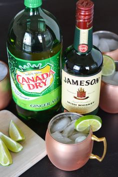 a bottle of jameson next to two glasses filled with ice and limes