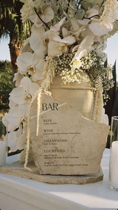 a table topped with a vase filled with white flowers