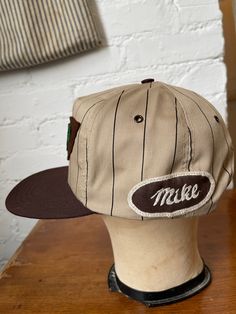 This is a vintage made is USA trucker style hat that I added vintage patches to! Wool 'MPP' patch from the 1940s, and an embroidered 'Mike' workwear name patch. One of a kind. Brown and tan with stripes. In deadstock condition. Adjustable snapback, one size fits most. Gender neutral. All sales are final, so please refer to photos and description. Vintage Cotton Snapback Hat With Logo Patch, Retro Cotton Snapback Cap, Vintage Baseball Cap For Baseball Season, Retro Cotton Snapback Hat With Logo Patch, Retro Cotton Trucker Hat With Flat Brim, Vintage Cotton Trucker Hat With Logo Patch, Vintage Cotton Snapback Hat For Outdoor, Retro Six-panel Baseball Hat, Retro Cotton Snapback Baseball Cap