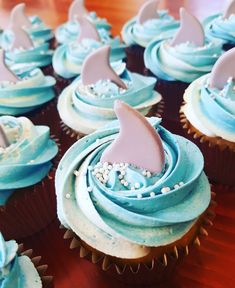 cupcakes with blue frosting and shark fin decorations