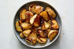 a bowl filled with cooked potatoes on top of a table