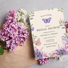 a purple flower and butterfly bridal shower card on top of an envelope with flowers