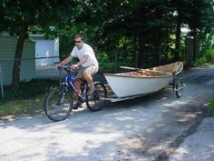 a man riding a bike next to a boat