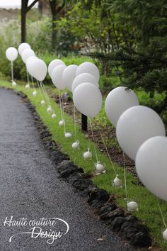 white balloons lined up along the side of a road