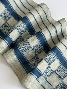 two pieces of cloth with blue and white designs on them, one is folded over the other