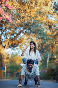 a man riding on top of a woman's back in the middle of a road