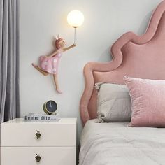 a pink headboard with a clock on the wall above it next to a bed