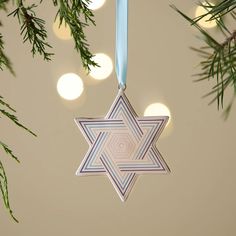 a star ornament hanging from a christmas tree