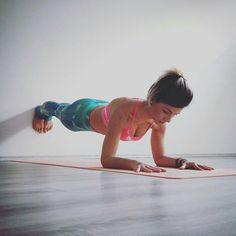 a woman doing push ups on a yoga mat