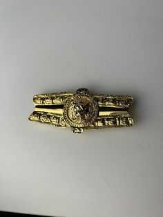 Gold tone Alexis Kirk belt buckle.  Etruscan style with a lion head in the center.    Measures 4 1/4 inches long and 2  inches wide.   Overall in very good condition -very minor wear A Lion, Lion Head, Belt Buckle, Belt Buckles, Lion, Gold Tones, Buckle, Red, Gold