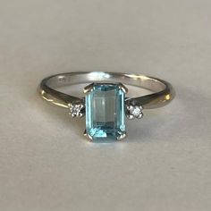 14K White Gold Aquamarine and Diamond Accent Ring, 2.4grams, size 6.25, very sparkly Weight: 2.4 grams Stones: Aquamarine Size Main Stone: ca. 7mm x 5mm Cut: Emerald Color: Light Blue Size Secondary Stone: Diamonds, ca. mm dia. Number of Gemstones: 3 Markings: unreadable, because worn out, but tested Bandwidth: ca. 1.5mm at smallest point  Tested: Niton DXL Precious Metal Analyzer- tested 14KT, Presidium Gemtester - tested Aquamarine (testing performed by 3rd person) Condition: Good preowned wit Aquamarine Ring Vintage, Aquamarine Ring, Emerald Color, Color Light Blue, Precious Metal, Antique Rings, Ring Vintage, Rings Statement, Little Gifts