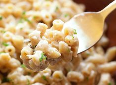 a spoon full of macaroni and cheese with parsley