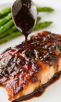 the salmon is being drizzled with bbq sauce on it's side