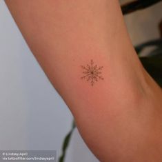 a small snowflake tattoo on the arm