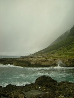 an ocean view with waves crashing on the rocks