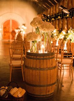 a barrel with flowers and candles in it