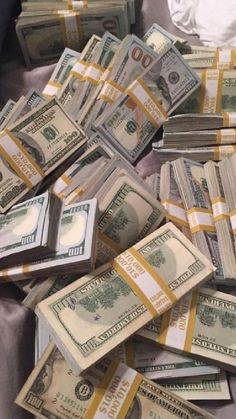 a pile of money sitting on top of a bed