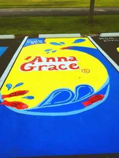 an amg grace sign painted on the side of a parking lot with grass in the background