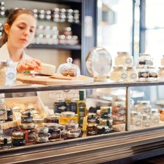 a woman standing in front of a counter filled with food