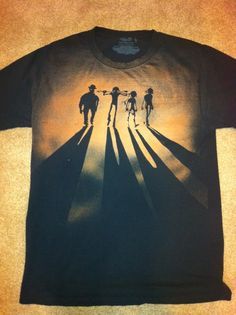 a t - shirt with the silhouettes of three people walking in front of them