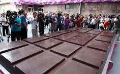 people standing in front of chocolate bars with the caption did you know? the largest chocolate bar in the world weighed 397 pounds