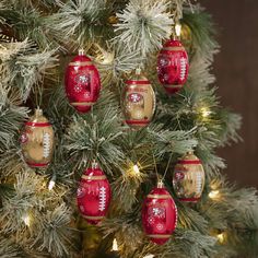 a christmas tree with ornaments hanging from it's branches in red and gold colors