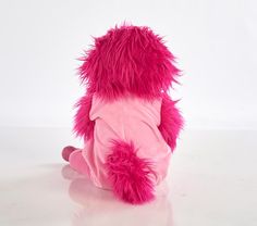 a pink stuffed animal sitting on top of a white floor