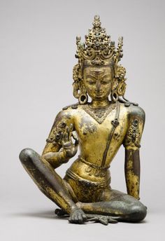 a golden buddha statue sitting on the ground