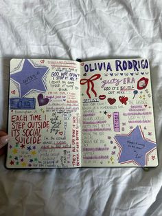 an open notebook with writing on it and stars in the pages that are handwritten