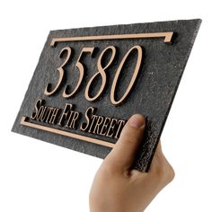 a person holding up a plaque that says 350 south fir street