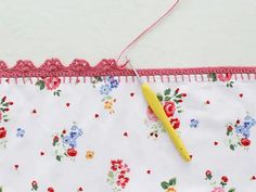 a yellow crochet hook is on the edge of a piece of fabric