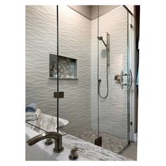 a bathroom with a walk in shower next to a white sink and mirror on the wall