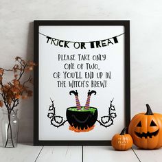 there is a framed poster with a trick or treat on it next to two pumpkins