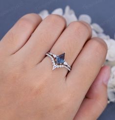 a woman's hand wearing a ring with an aqua blue and white topazte