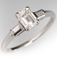 an emerald cut diamond ring with baguettes on the sides and tapered shoulders