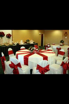 the banquet room is decorated with red and white linens, bows, and flowers