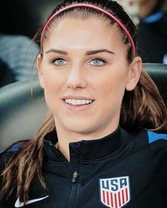 a beautiful young woman sitting in the back seat of a car wearing a usa flag headband