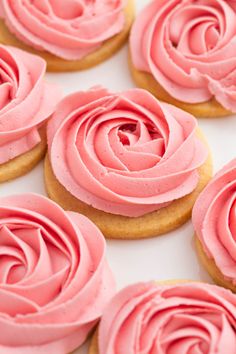 some pink frosted cupcakes on a white plate