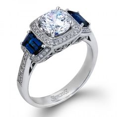 a diamond and blue sapphire engagement ring with diamonds on the sides, set in 18k white gold