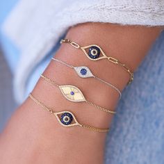 Protect yourself from harm with this modern Fluted Elongated Diamond And Sapphire Evil Eye Bracelet. Wear alone or stack with other bracelets. Available in 14k yellow gold (2.54g) With .11ct tw SI G-H diamonds With .07ct blue sapphire Evil eye width is approximately .75" Evil eye height is approximately .33" Length is adjustable from 6" to 7" Spring ring clasp Gift wrap available Diamond Huggie Earrings, Daisy Bracelet, Diamond Bangles Bracelet, Bracelets Gold Diamond, Heart Chain, Bad Luck, Fancy Jewellery, Star Bracelet, Gold Bangle Bracelet