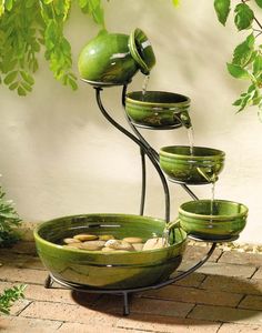 a water fountain with green bowls on it