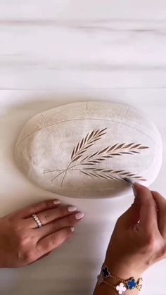 two hands holding a white object on top of a table