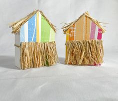 two small houses made out of straw on a white background