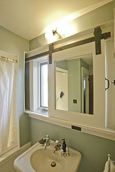 a white sink sitting under a bathroom mirror next to a bathtub and shower curtain