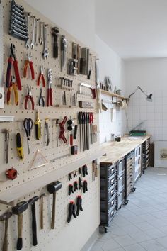 the tools are hanging on the wall in the room with all kinds of work tools