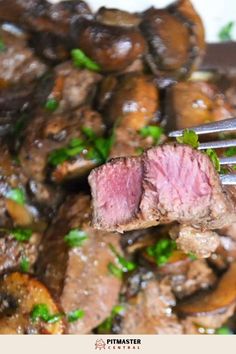 a piece of steak on a fork with mushrooms