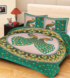 a bed with a green and yellow comforter set on top of a wooden floor