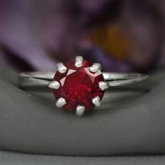 This dramatic Sterling Silver 8-prong Round Ruby Ring features a sparkling 8 mm round gemstone. The detailing on the setting mimics a basic lattice design that includes the the delicate prongs. When antiqued, this simple design emphasizes the deep color of the stone. The ring tapers gracefully from the stone to a 2.3 mm band, and the stone stands a captivating 7 mm high to gather plenty of attention! Although this piece is shown as created with a ruby, we are happy to create this ring with your Classic Crystal Ring With Birthstone In Round Cut, Classic Crystal Birthstone Ring With Round Cut, Dazzling Brilliant Cut Ruby Ring Gift, Dazzling Brilliant-cut Ruby Ring For Gift, Classic Round Crystal Birthstone Ring, Gift Ruby Ring With Cubic Zirconia, Solitaire Birthstone Ring For Proposal, Solitaire Birthstone Ring With Round Cut For Proposal, Round Cut Solitaire Birthstone Ring For Proposal