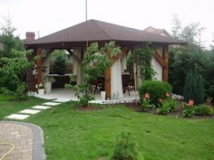 a gazebo sitting in the middle of a lush green yard next to a fire hydrant