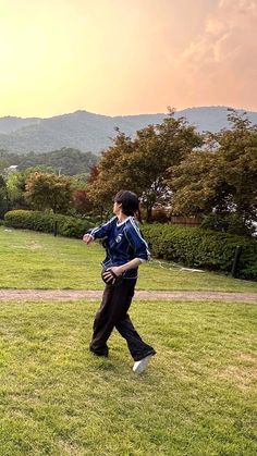 a man standing on top of a lush green field holding a frisbee in his hand